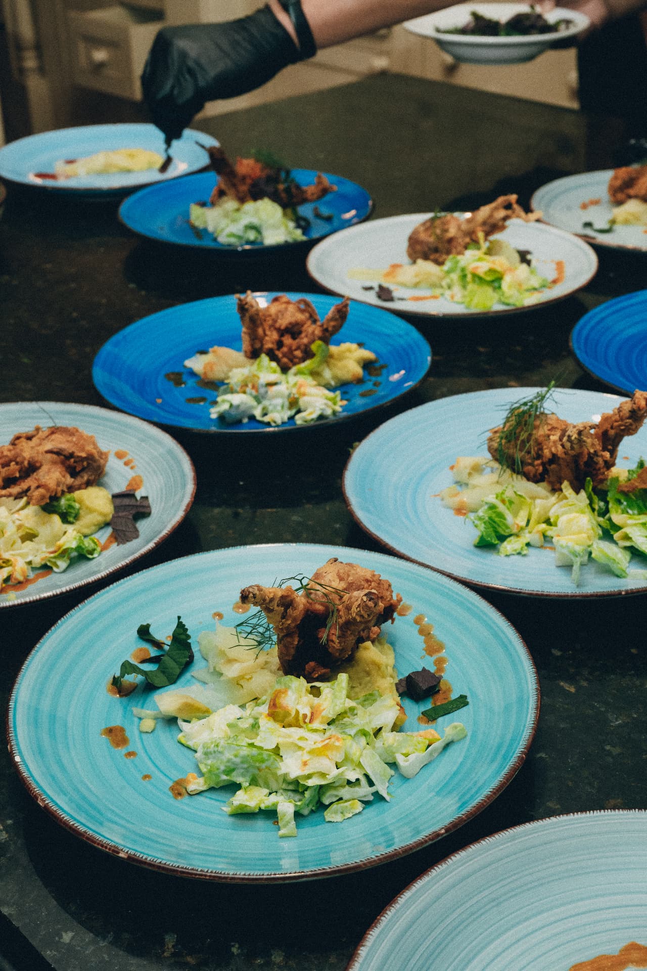 Plated courses on blue plates ready to be served