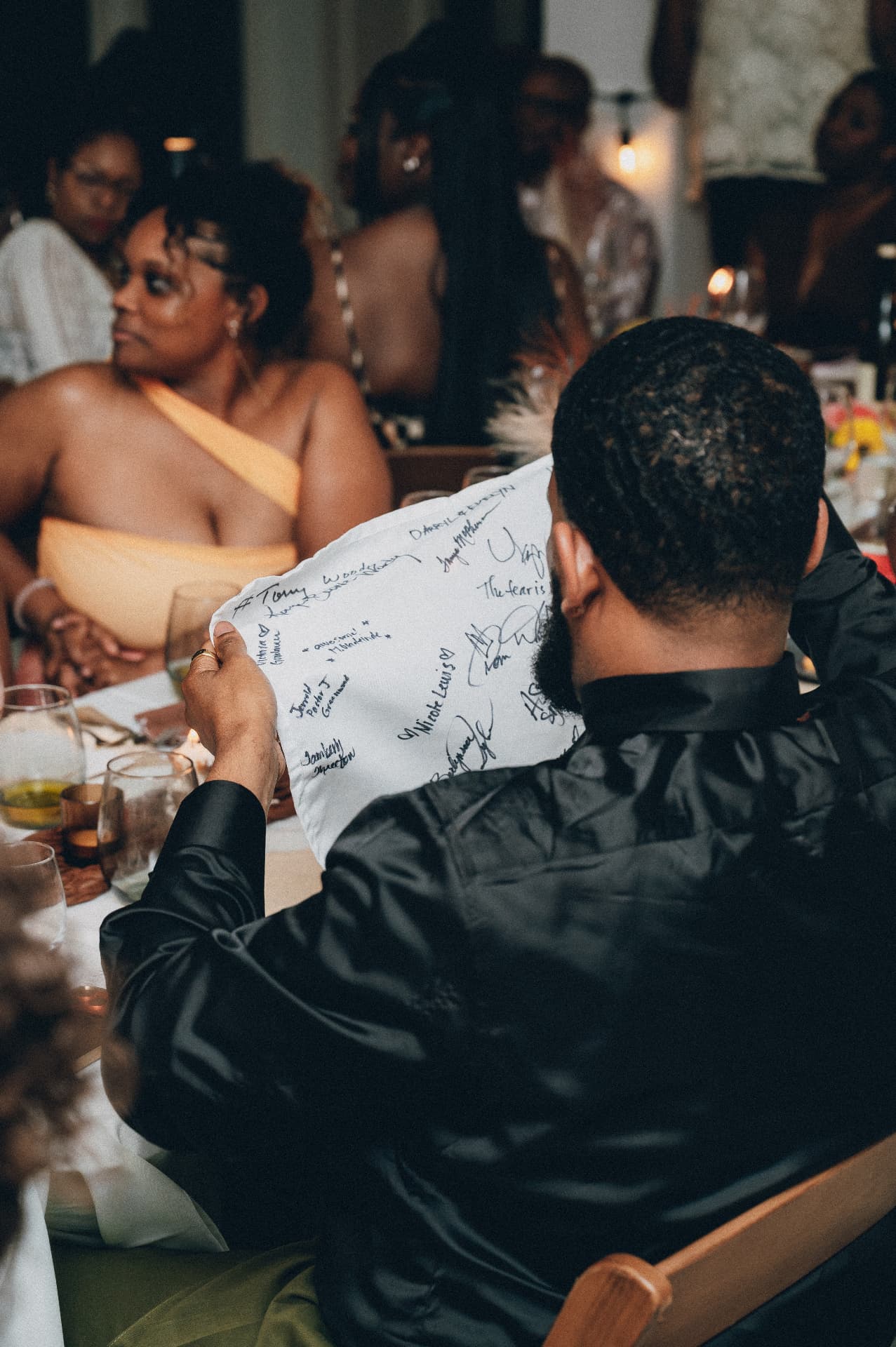 A guest reading a napkin signed by everyone at the table