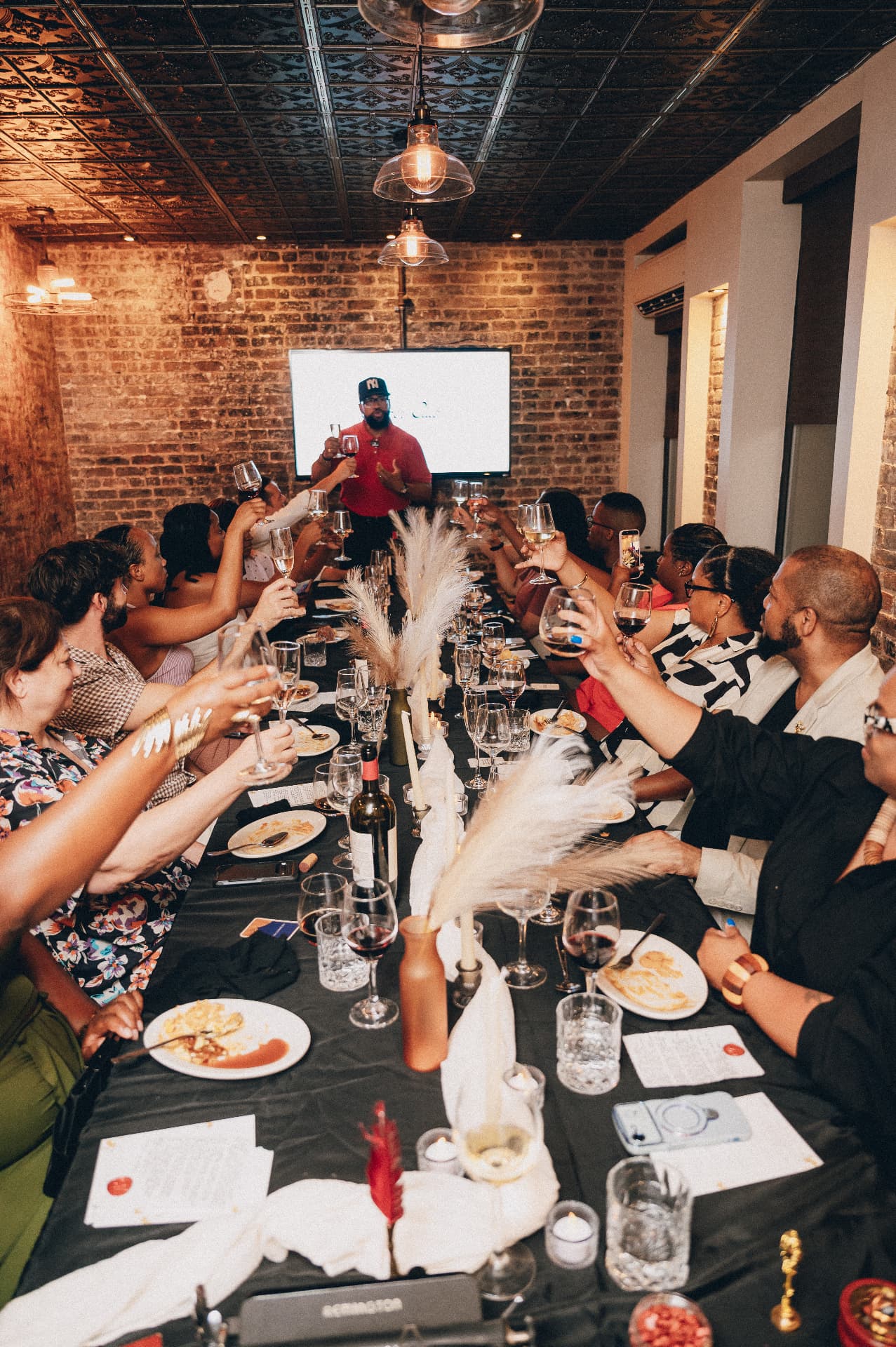 Guests raising their glasses around the long table during the evening